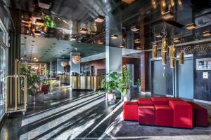 a lobby with a red couch in the middle at Hotel Jutlandia in Frederikshavn