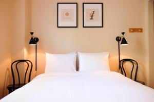 a bedroom with a large white bed with two lamps at Dancing Bear Inn Hostel in Nelson