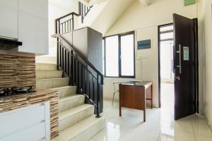 a staircase in a room with a table and a desk at OYO 3826 Columbus Residence K11 in Karawang