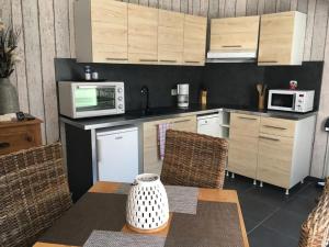 a kitchen with wooden cabinets and a table with a vase at La Vague in Yport