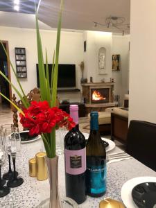 twee flessen wijn zittend op een tafel met bloemen bij Luxury Villa Borina in Zheleznitsa