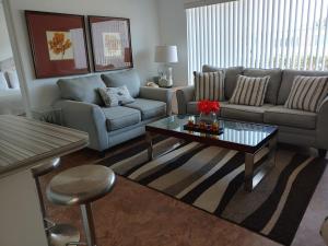 a living room with a couch and a coffee table at Sunrise Ocean Suites in Pompano Beach