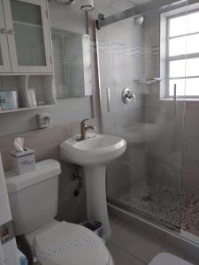 y baño con aseo, lavabo y ducha. en Sunrise Ocean Suites, en Pompano Beach