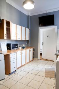 uma cozinha com armários brancos e piso em azulejo branco em Ionia Apartment - Stary Rynek- em Poznań