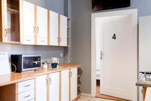 uma cozinha com armários brancos e um micro-ondas em Ionia Apartment - Stary Rynek- em Poznań