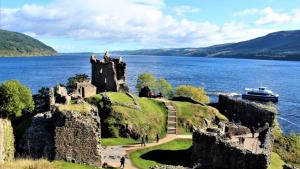 a castle on the shore of a body of water at Apartment 101 Kingsmills Road in Inverness