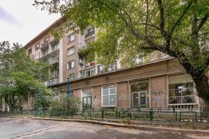 un edificio de apartamentos en una calle con un árbol en MAYAHouse, en Bucarest