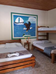 Hotel Costa Mar Coveñas في كوفيناس: غرفة نوم بسريرين ولوحة قارب