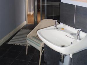 ein Badezimmer mit einem Waschbecken, einer Bank und einer Dusche in der Unterkunft Duken Courtyard Cottage in Bridgnorth + 12 Fotos