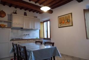 een keuken met een tafel en een tafel en stoelen bij CASA SERENA in Montepulciano