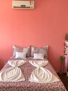 um quarto com uma cama com uma parede rosa em Pousada Sol Nascente em Barreirinhas