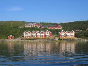una fila de casas en la orilla de un cuerpo de agua en Tjeldsundbrua Maritim, en Evenskjer