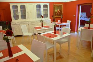 un comedor con mesas blancas y sillas blancas en B&B Le Quattro Fontane, en Gravina in Puglia