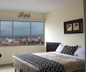 una camera da letto con un letto e una grande finestra di Hotel Doral a Città di Panama