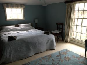 Duken Courtyard Cottage في بريدغنورث: غرفة نوم بسرير كبير ونوافذ