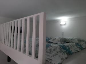 a white bedroom with a bed and a crib at Apartamento Guarujá - Pitangueiras in Guarujá