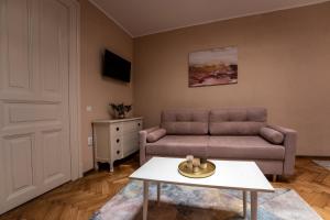 a living room with a couch and a table at Rendez-vous Apartment in Sighişoara