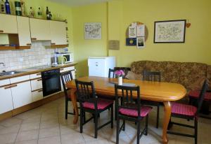 cocina con mesa de madera y sillas en Apartmány Černá Voda, en Černá Voda 15 fotos más