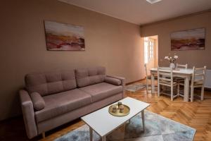 a living room with a couch and a table at Rendez-vous Apartment in Sighişoara