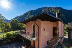 Casa pequeña con balcón y montañas al fondo en Cariel, en Antronapiana