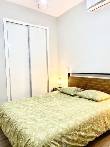 una camera con letto e copriletto verde di Centro de Carabanchel Calle Binefar a Madrid