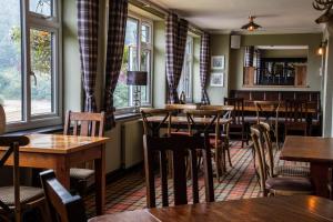 a restaurant with tables and chairs and windows at The Windmill Inn in Watchet