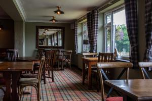 a dining room with tables and chairs and a window at The Windmill Inn in Watchet