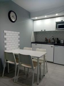 una cocina con mesa y sillas y un reloj en la pared en Alfastudio en Breuil-Cervinia