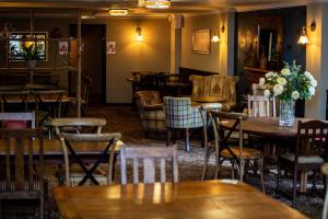 a restaurant with wooden tables and chairs and flowers on the wall at The Windmill Inn in Watchet