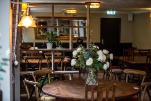 a vase of flowers on a table in a restaurant at The Windmill Inn in Watchet