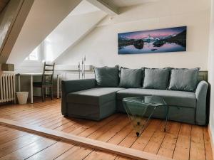 a living room with a couch and a table at CityLodge St Gallen - 2 min to Marktplatz in St. Gallen