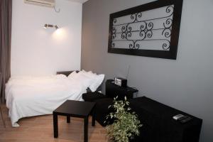 1 dormitorio con cama blanca y mesa negra en Mrežnički kutak en Duga Resa