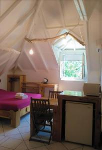 a room with a table and a dining room with a tent at Gites Rose des Vents in Deshaies