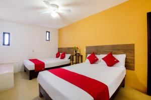 a bedroom with two beds with red and white pillows at Hotel Villa Hermosa in Oaxaca City +20 photos