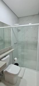 uma casa de banho com um WC e uma cabina de duche em vidro. em Hi Adventure em Florianópolis