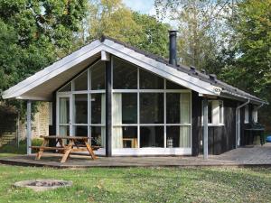 eine kleine Hütte mit einem Picknicktisch im Gras in der Unterkunft 8 person holiday home in Hadsund in Øster Hurup