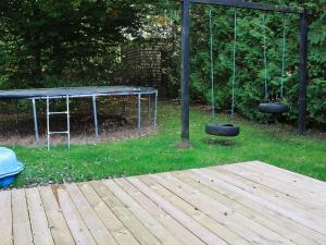 a swing set with two tires in a yard at 8 person holiday home in Hadsund in Øster Hurup