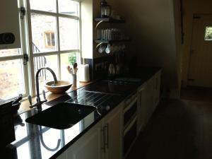 a kitchen with a counter and a sink and a window at Duken Courtyard Cottage in Bridgnorth