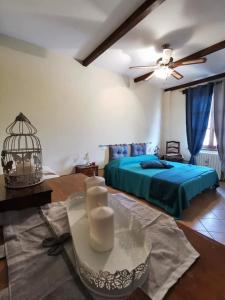 Un dormitorio con una cama azul y una mesa con velas en Agriturismo Mondo, en Bubbio