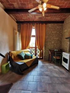 1 dormitorio con 1 cama y ventilador de techo en Agriturismo Mondo, en Bubbio