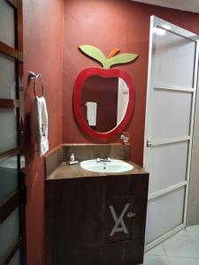 Baño con lavabo y manzana en la pared en Hotel Posada Victor Antonio en Zacatlán