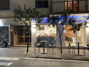 een winkel met tafels en stoelen voor een gebouw bij Caruso Rooms in Sorrento