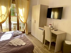 een slaapkamer met een bed, een bureau en een tafel bij Caruso Rooms in Sorrento