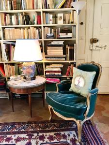 un salon avec une table, une chaise et une lampe dans l'établissement Logis Saint-Flaceau, au Mans