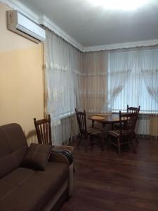 a living room with a table and chairs and a couch at Apartments comfortablе in Chernivtsi +10 photos