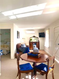 ein Wohnzimmer mit einem Tisch und ein Schlafzimmer in der Unterkunft Farm Cottage close to Dubbo in Dubbo