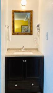 a bathroom with a sink and a mirror at Desert Inn in Van Horn