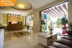 a living room with a couch and a large window at Magnolia Hotel Cam Ranh in Cam Ranh