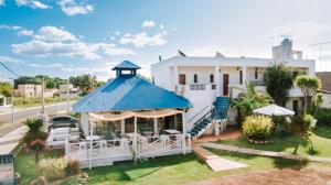 a white house with a blue roof at Posada del Navegante in Carmelo