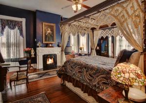 萨凡纳麦克米兰旅馆 的一间卧室设有一张天蓬床和一个壁炉